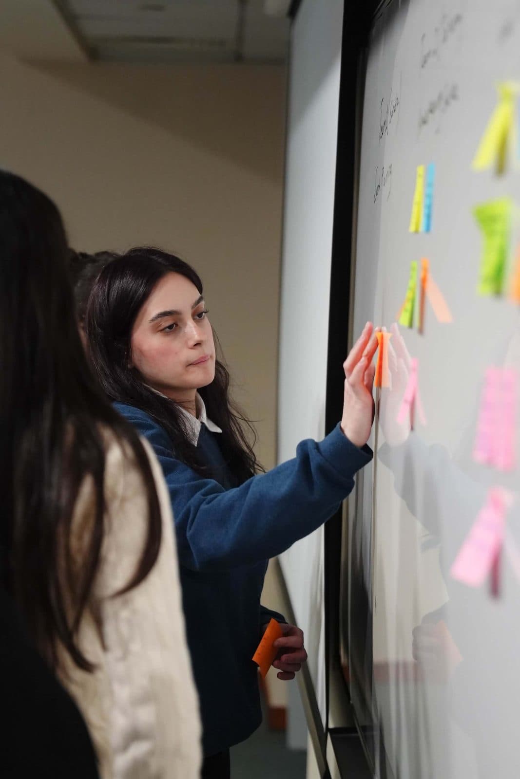 A student working at the wall during a class exercise