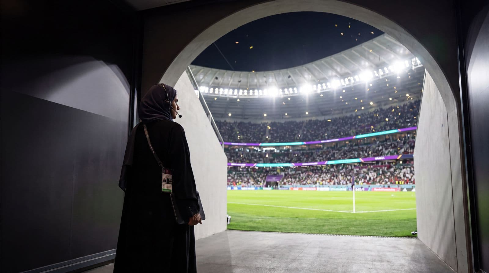 An event professional looking out from the tunnel onto a full stadium